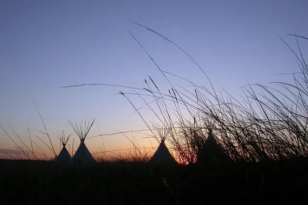A tipi on the prairie at sunset