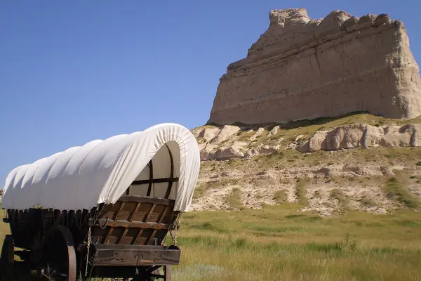 A covered wagon below the bluff