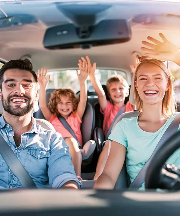 A family laughing together in the car on a road trip