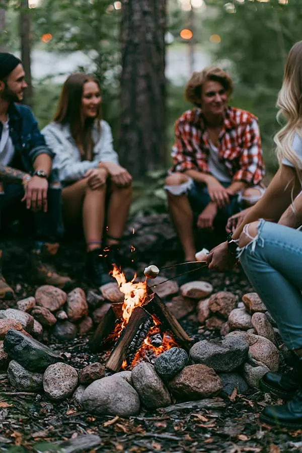 Road trippers gathered around a campfire — the support group